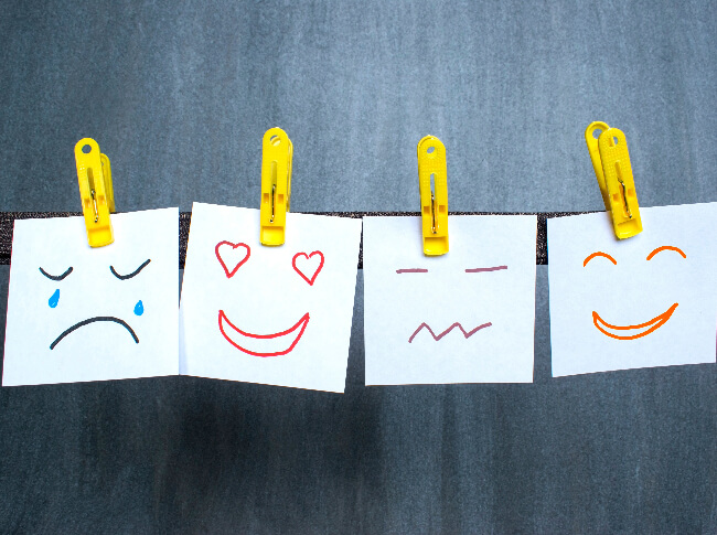 A picture of post it clipped to a line that shows a range of emotions.