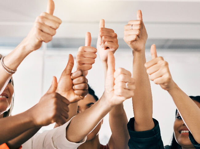 A diverse group displaying thumbs up