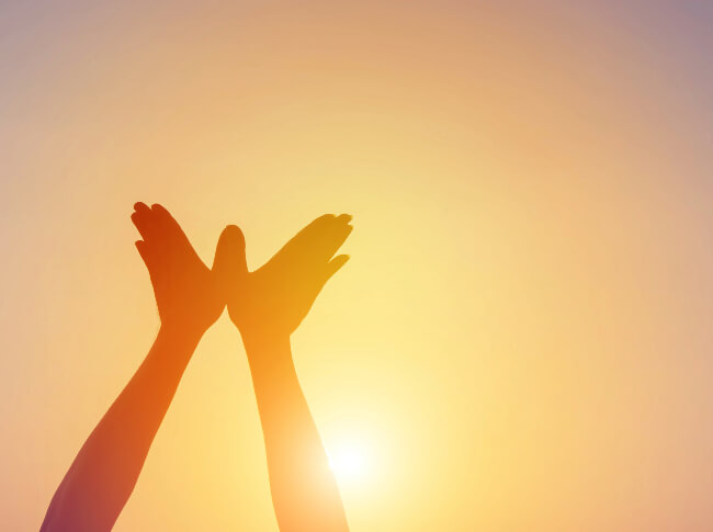 a person with their hands to the sky shaped like either a bird or butterfly
