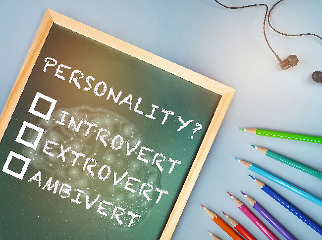understanding personality - a board with introvert, extrover, and ambivert on it with a headphone and pencils next to it.