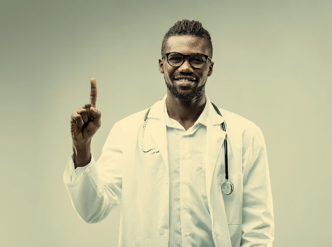 A doctor with one index finger pointed towards the ceiling