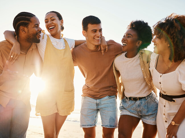 A group of smiling young adults embracing.