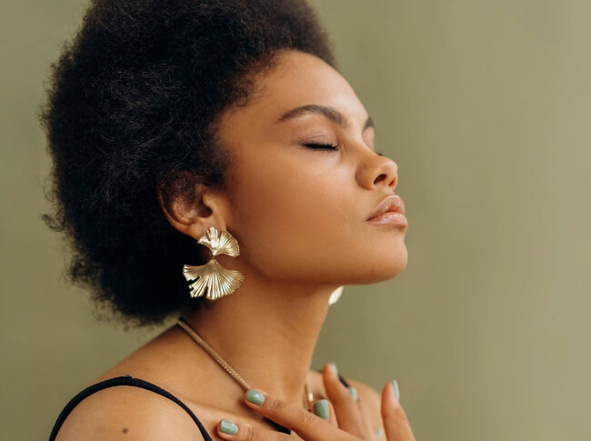 a woman with her eyes closed with her hand crossed over her chest