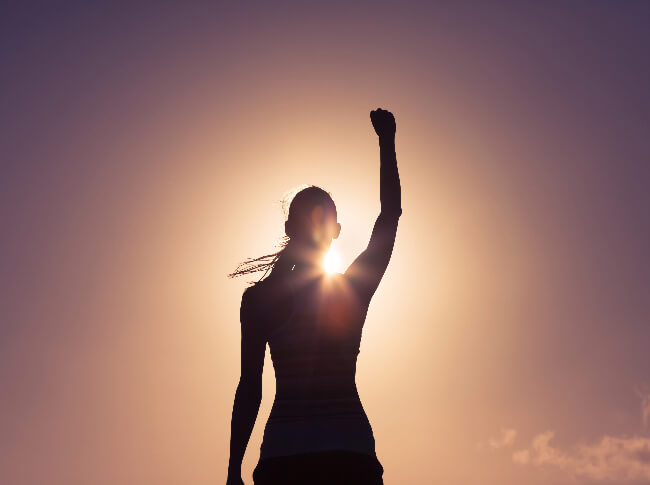  woman with her back to the camera with one hand up.