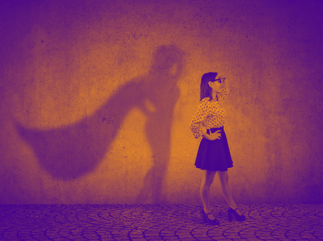 A white woman with a shadow image that has a cape which represents confidence.